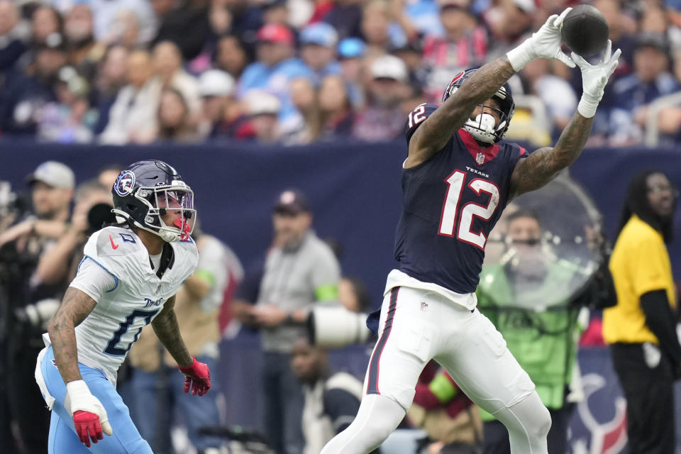 Houston Texans wide receiver Nico Collins (12) makes a catch over Tennessee Titans cornerback Sean Murphy-Bunting (0) during the first half of an NFL football game Sunday, Dec. 31, 2023, in Houston. (AP Photo/Eric Christian Smith)