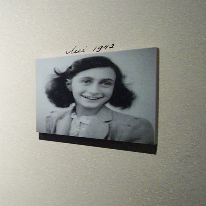 Photos of Anne Frank displayed on a wall