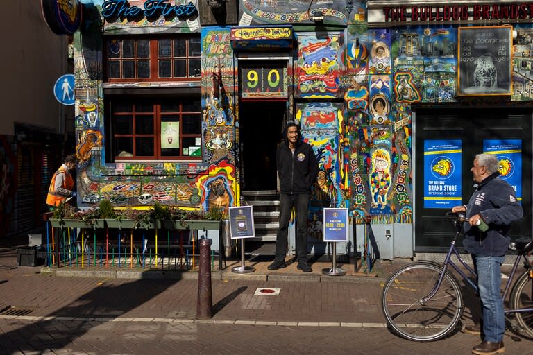 Un empleado se encuentra frente a una café en el Barrio Rojo de Ámsterdam el 26 de marzo de 2021