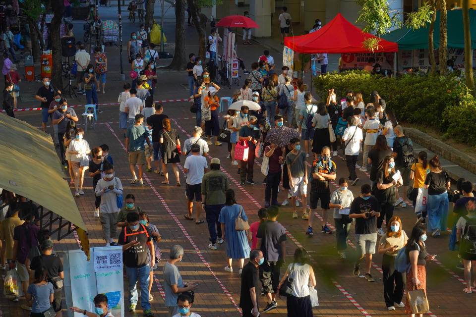 People queue up to vote in Hong Kong, Sunday, July 12, 2020, in an unofficial primary for pro-democracy candidates ahead of legislative elections in September. Over 200,000 Hong Kongers voted in an unofficial Hong Kong primary that will help the pro-democracy camp decide which candidates to field in legislative elections in September. The turnout exceeded organizers' estimates that some 170,000 people would turn up to vote over the weekend. (AP Photo/Vincent Yu)