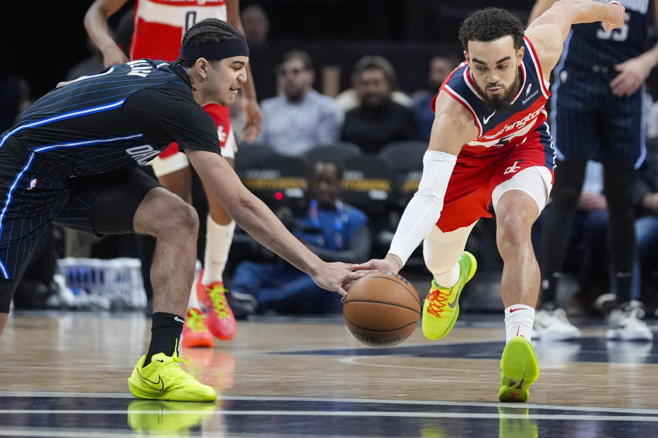 Orlando Magic guard Anthony Black, left, and Washington Wizards guard Tyus Jones go for a loose ball during the first half of an NBA basketball game Wednesday, March 6, 2024, in Washington. (AP Photo/Alex Brandon)