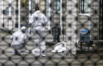 Forensic experts examine the crime scene next to a covered body following a shooting at the entrance of Building E of the courthouse in Frankfurt January 24, 2014. REUTERS/Ralph Orlowski (GERMANY - Tags: CRIME LAW)