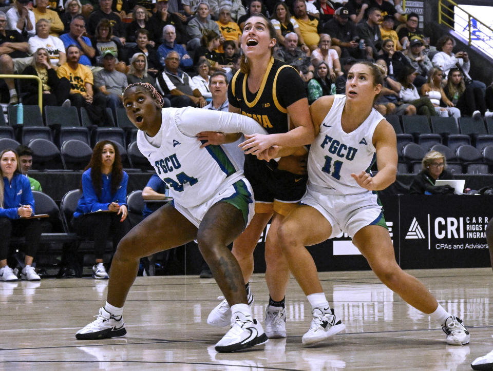 Florida Gulf Coast's Uju Ezeudu (24) and Maddie Antenucci (11) box out Iowa guard Kate Martin (20) during the first half of an NCAA college basketball game in Gulf Coast Showcase, Saturday, Nov. 25, in Estero, Fla. (AP Photo/Steve Nesius)