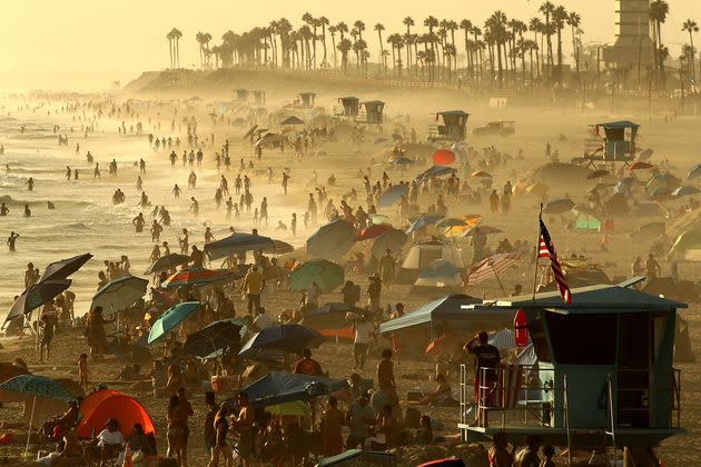 People crowd the beach as fog drifts ashore at sunset in Huntington Beach, California, on Monday. (Photo: Luis Sinco via Getty Images)