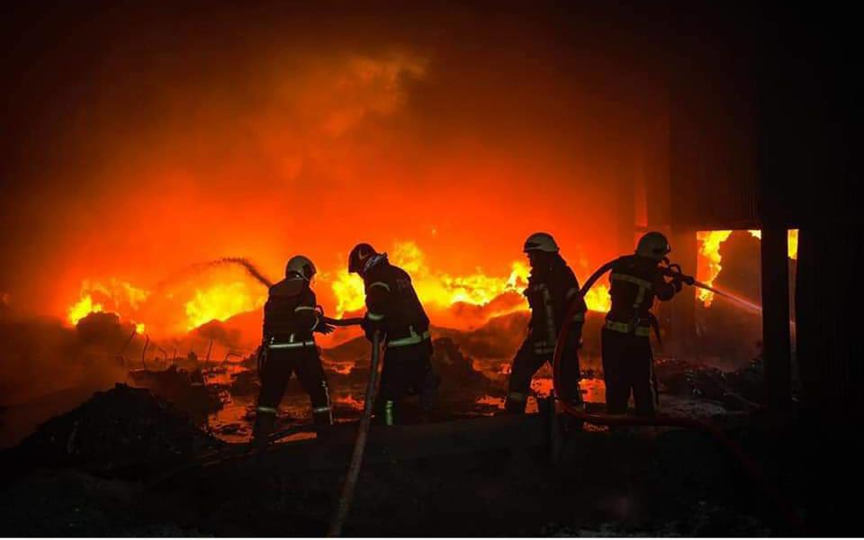 Firefighters of the State Emergency Service (DSNS) work to put out the fire which erupted in a warehouse after several explosions hit Kyiv - Shutterstock