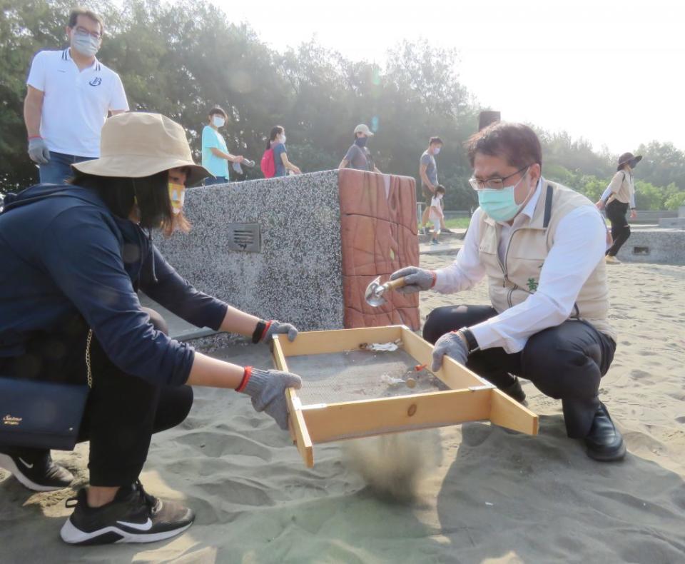 市長黃偉哲手持鏟子清除沙灘小垃圾。（記者陳治交攝）