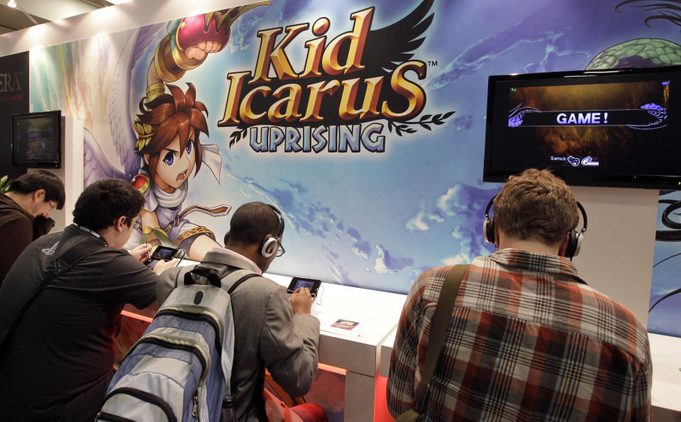 Adolescentes jugando a una versión actual del videojuego "Kid Icarus", el mismo que se encontró sin abrir en el desván de su madre Scott Amos. Foto: AP Photo/Paul Sakuma.