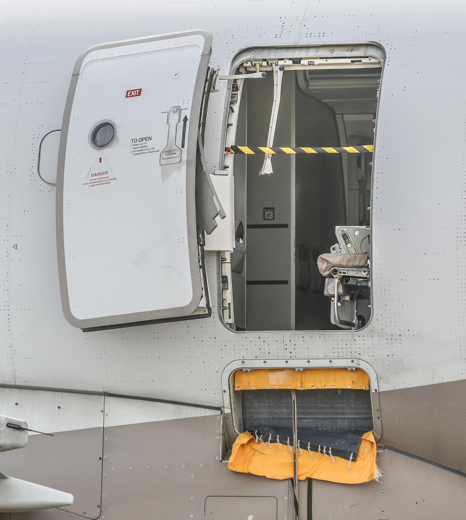 An emergency exit door of an Asiana Airlines plane is seen at Daegu International Airport in Daegu, South Korea, Friday, May 26, 2023, after a passenger opened it during a flight. A passenger opened the emergency exit door during a South Korean flight Friday, causing air to gust inside the cabin before the plane landed safely, airline and government officials said.