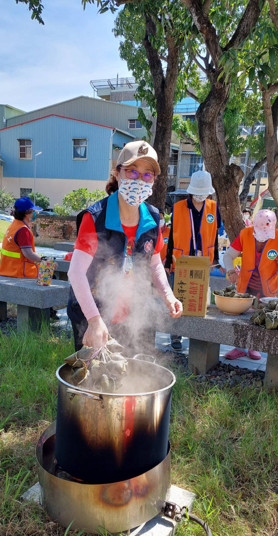 圖片說明 :現包現煮粽香四溢磚磘志工滿身大汗。(記者劉治強攝)