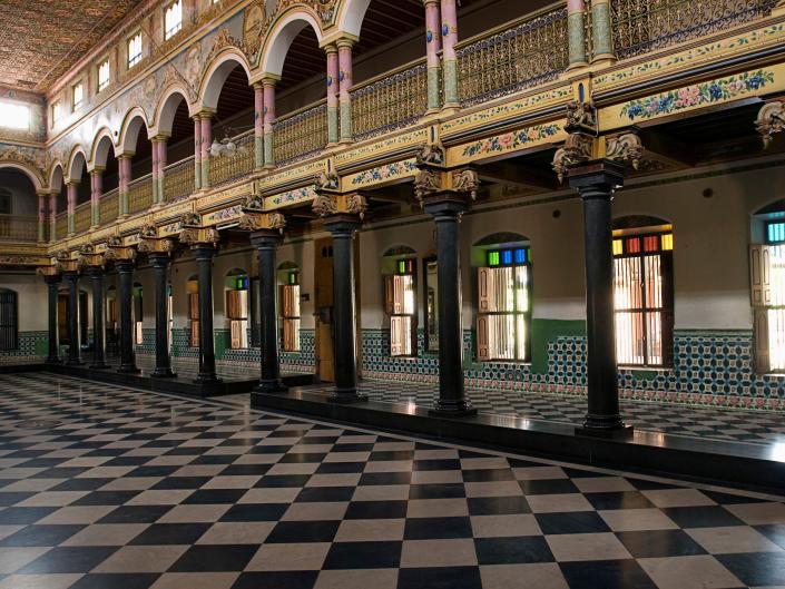 Inside a mansion house in Athangudi near Karaikudi, Chettinad, Tamil Nadu, India in 2007. Light pours in from the numerous windows behind the pillars of the hall.
