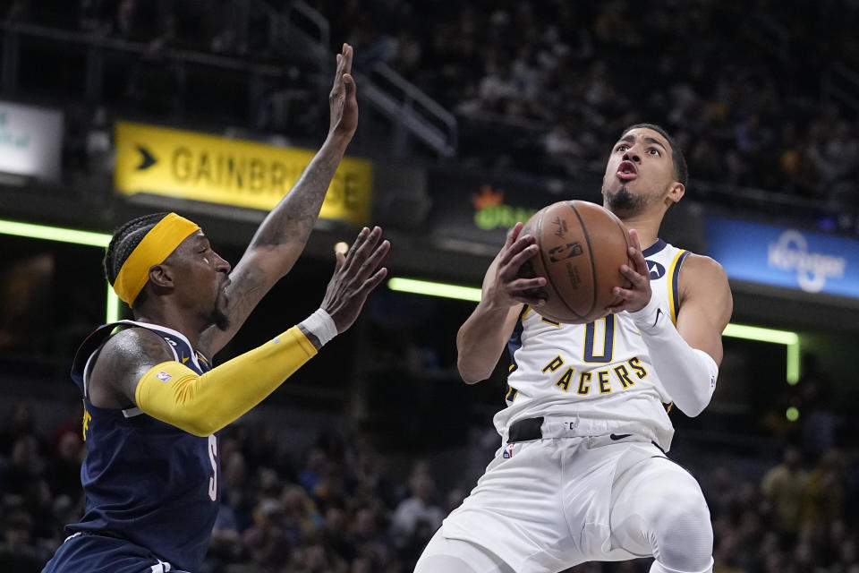 Indiana Pacers' Tyrese Haliburton (0) puts up a shot against Denver Nuggets' Kentavious Caldwell-Pope (5) during the second half of an NBA basketball game, Wednesday, Nov. 9, 2022, in Indianapolis. Denver won 122-119. (AP Photo/Darron Cummings)