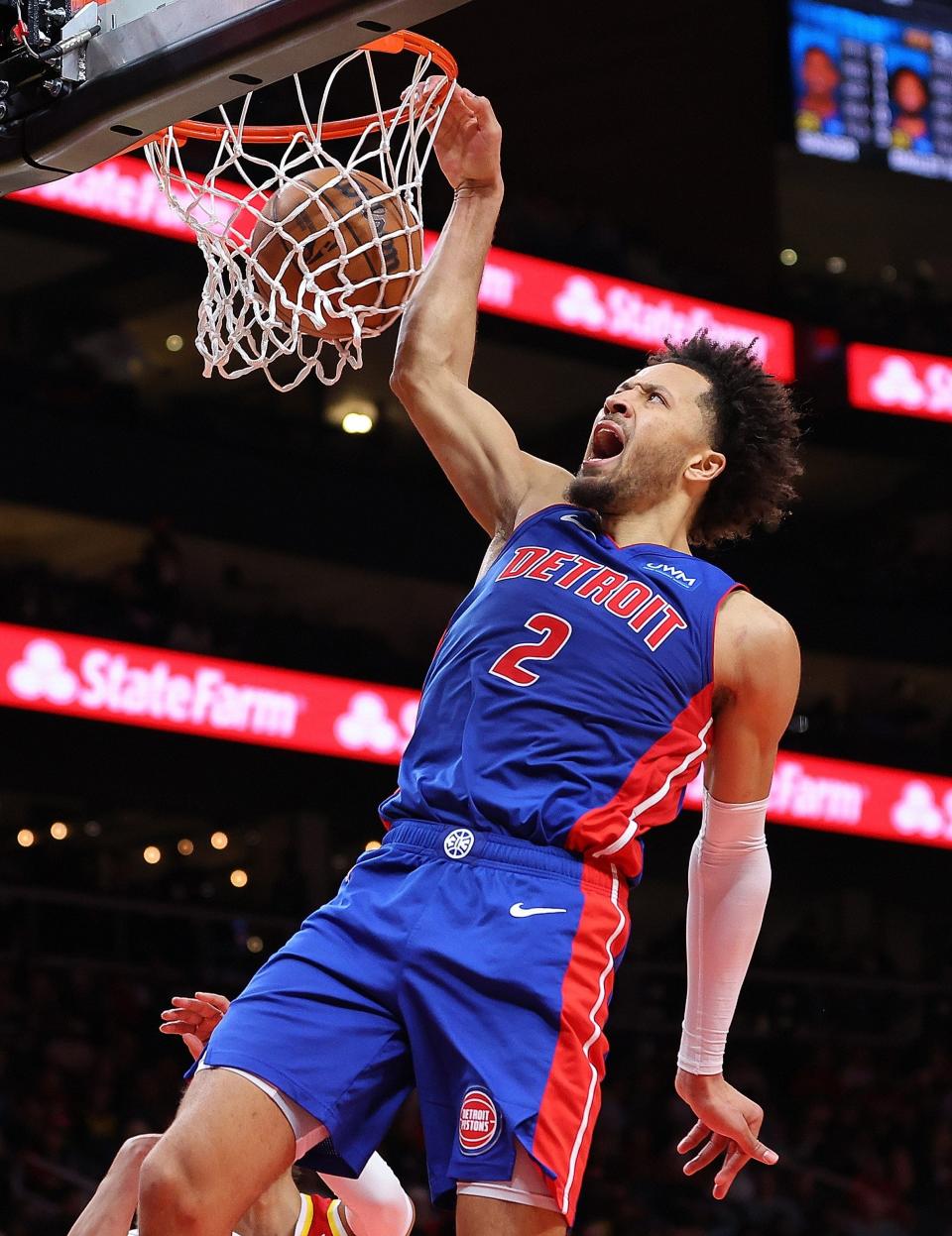 Pistons guard Cade Cunningham draws a foul as he dunks against Hawks guard Trae Young during the fourth quarter of the Pistons' 130-124 loss on Monday, Dec. 18, 2023, in Atlanta.