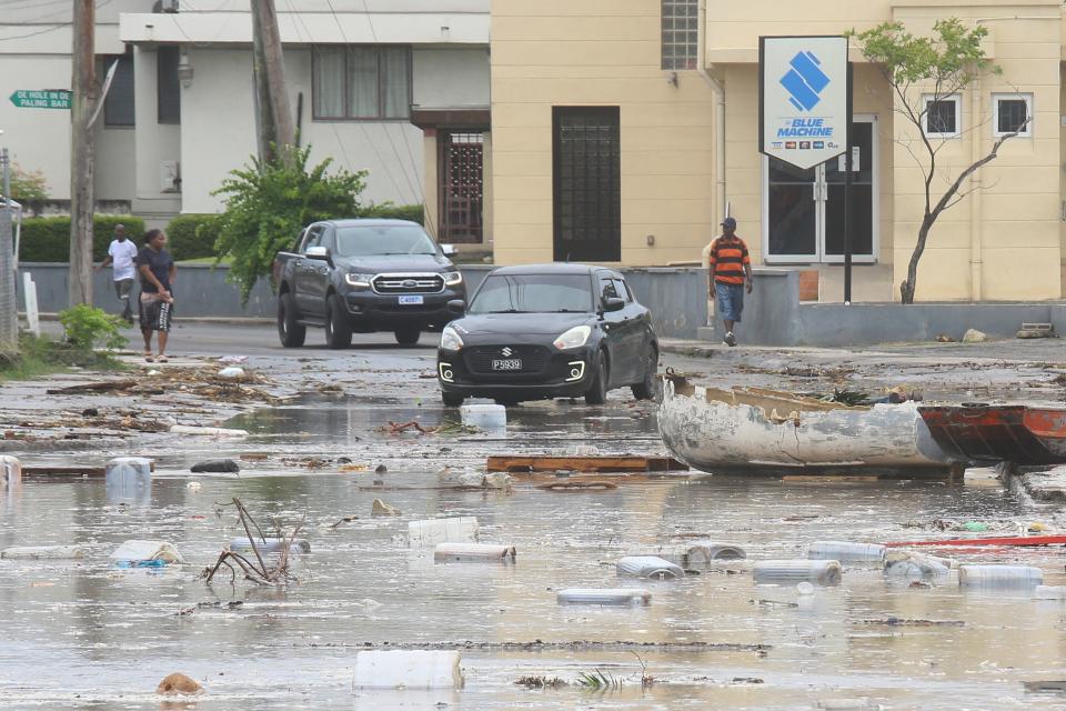 Cars drive through a debris-filled street in Bridgetown, Barbados after Hurricane Beryl blew through the island (REUTERS)