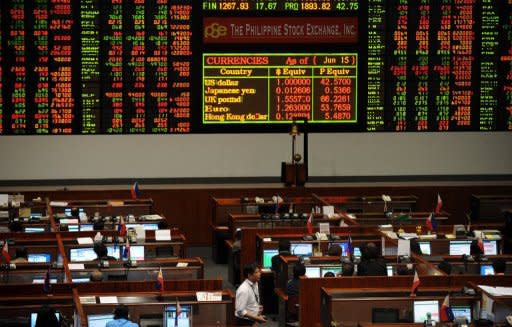 Traders work at the Philippine Stock Exchange in Manila. Asian markets mostly fell as fears about Spain's surging borrowing costs replaced the previous day's optimism over Greece's election, while G20 leaders struggled to soothe dealers' nerves