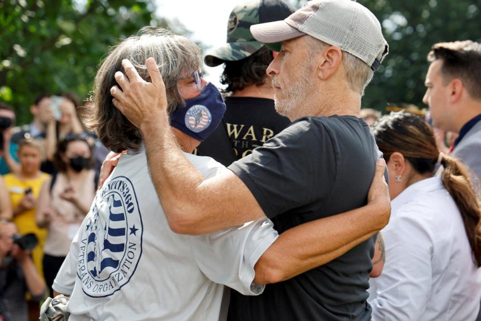 El cómico Jon Stewart abraza a Susan Zeier en la rueda de prensa del 28 de julio (REUTERS)