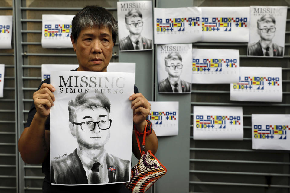 A supporter holds a poster outside of the British Consulate in Hong Kong during a rally in support of an employee of the consulate who was detained while returning from a trip to China, Wednesday, Aug. 21, 2019. China said Wednesday a staffer at the British consulate in Hong Kong has been given 15 days of administrative detention in the city of Shenzhen for violating a law on public order. (AP Photo/Vincent Yu)