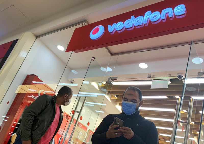 FILE PHOTO: Shoppers wear protective face masks in front of a Vodafone store inside a City Centre mall ahead of Black Friday in Cairo