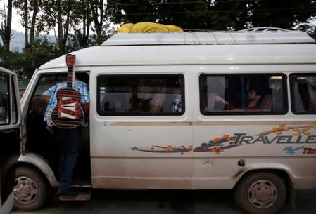 A foreign tourist boards a passenger vehicle as he along with others leave Srinagar