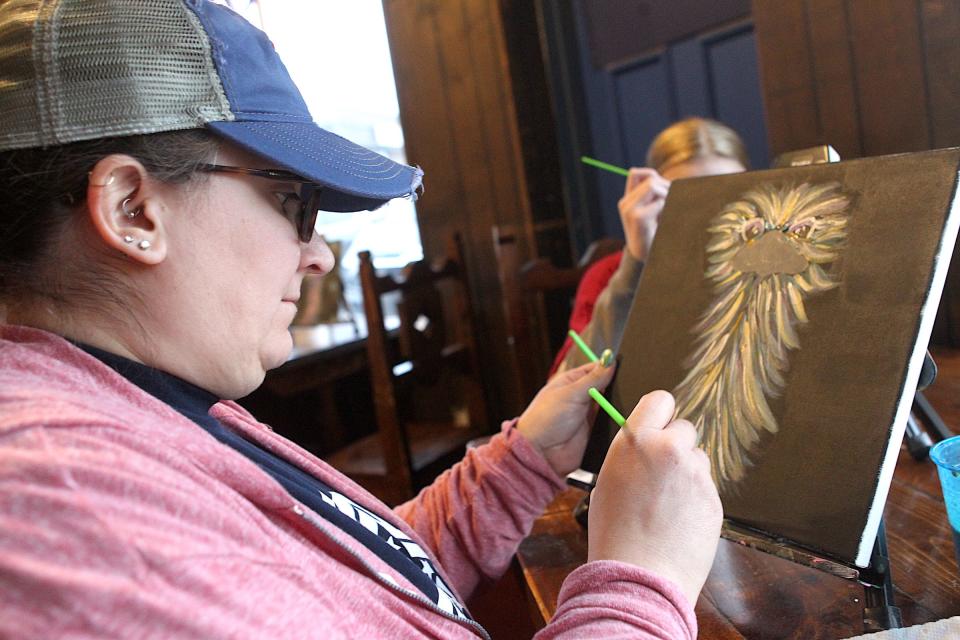 Christie Cummings works on her painting during the Tink's Fine Art class "That's so Emusing" held at the Ranch Del Burrito restaurant in Bedford Tuesday evening. Cummings said she has taken Tink's Fine Art classes before, and "I am making progress."