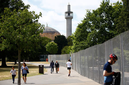 Pedestrians pass a security fence leading to Regent's Park Mosque, near the U.S. ambassador's residence, ahead of the U.S. presidential visit, in Regents Park, London, Britain July 11, 2018. REUTERS/Henry Nicholls