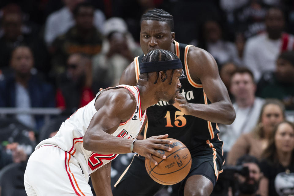 Miami Heat forward Jimmy Butler, left, dribbles against Atlanta Hawks center Clint Capela, top, during the first half of an NBA basketball game, Monday, Jan. 16, 2023, in Atlanta. (AP Photo/Hakim Wright Sr.)