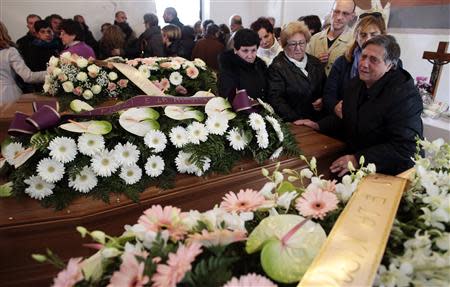 Relatives stand around three coffins during a funeral service for some victims of an extreme rainfall at Tempio Pausania on Sardinia island November 20, 2013. REUTERS/Tony Gentile