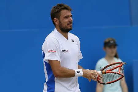 Switzerland's Stanislas Wawrinka holds a destroyed racquet during his men's singles semi-final tennis match against Bulgaria's Grigor Dimitrov at the Queen's Club Championships in west London June 14, 2014. REUTERS/Stefan Wermuth