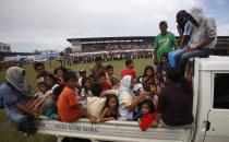 Residents arrive at a stadium that has been turned into a evacuation centre after fleeing their homes due to fighting between Moro National Liberation Front rebels (MNLF) and government soldiers in Zamboanga city September 11, 2013. (REUTERS/Erik De Castro)