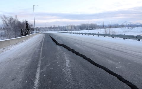 A crack which opened up along a roadway near the airport is seen after an earthquake in Anchorage - Credit: Reuters