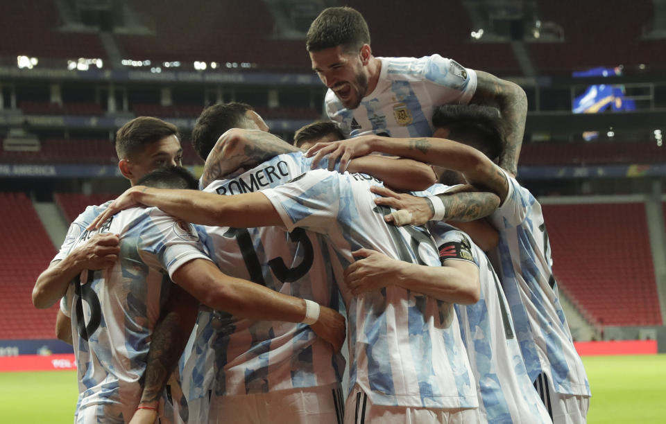 Players of Argentina celebrate their side's opening goal against Uruguay scored by teammate Guido Rodriguez during a Copa America soccer match at the National Stadium in Brasilia Brazil, Friday, June 18, 2021. (AP Photo/Eraldo Peres)