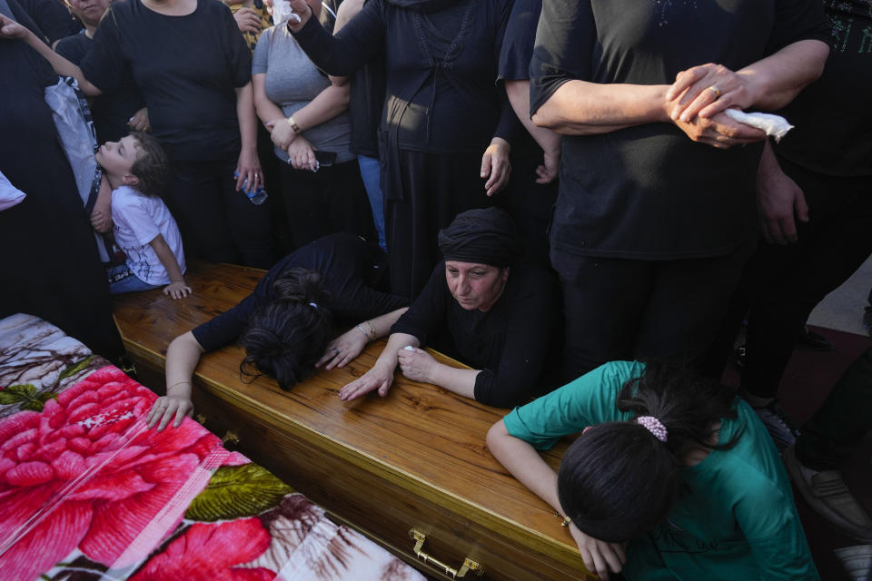 Amigos y familiares durante el funeral de las personas que murieron en un incendio durante una boda en Hamdaniya, Irak, el miércoles 27 de octubre de 2023. (AP Foto/Hadi Mizban)