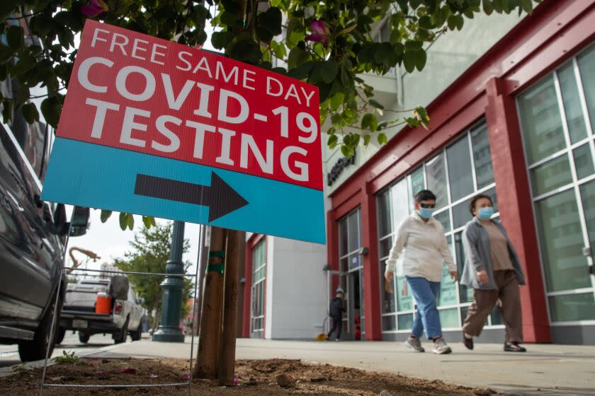 Los Angeles, CA - December 06: Los Angeles County appears in the midst of another full-blown coronavirus surge, with cases rising by 75% over the last week. The spike is prompting increasingly urgent calls for residents to get up to date on their vaccines and consider taking other preventative steps to stymie viral transmission and severe illness. A shopper in face mask walks along Broadway on Tuesday, Dec. 6, 2022 in Los Angeles, CA. (Irfan Khan / Los Angeles Times)