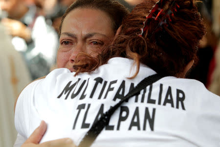 Residents of the Tlalpan housing project, affected by the September 2017 earthquake, react after a minute of silence to honour the victims of the quake in Mexico City, Mexico September 19, 2018. REUTERS/Daniel Becerril