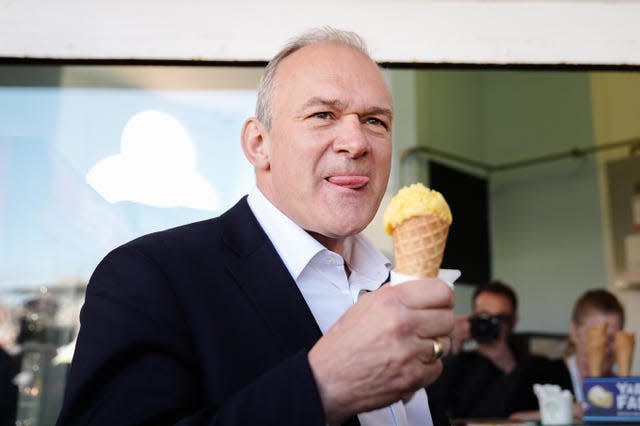 Liberal Democrat leader Sir Ed Davey eats ice cream on the promenade in Eastbourne, East Sussex