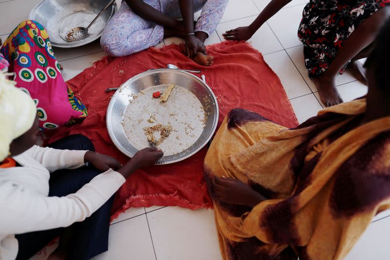 Youth who is eight months pregnant and said she was raped by her friend, eats her lunch at La Maison Rose in Dakar