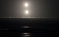 The SpaceX Falcon heavy rocket boosters return to land after a successful launch from the Kennedy Space Center in Cape Canaveral, Fla., early Tuesday, June 25, 2019. The Falcon rocket has a payload military and scientific research satellites. (AP Photo/John Raoux)