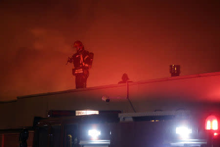 A firefighter works on the roof of a night club that was destroyed by a fire in Bucharest, Romania, January 21, 2017. Inquam Photos/Octav Ganea/via REUTERS