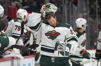 Minnesota Wild goaltender Filip Gustavsson puts on his mask after a quick repair in the first period of an NHL preseason hockey game against the Colorado Avalanche Tuesday, Sept. 27, 2022, in Denver. (AP Photo/David Zalubowski)