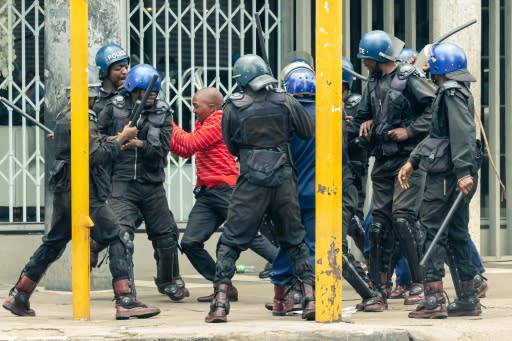 As the crowd danced to songs blaring from speakers on the party office balcony, baton-wielding police surrounded them