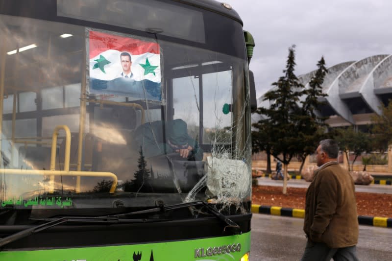 Un chauffeur d'autobus attend pour évacuer des gens à Alep. De violents combats ont repris mercredi matin dans Alep après le report de l'évacuation des civils et des combattants insurgés qui devait débuter à l'aube dans la grande ville du nord de la Syrie. /Photo prise le 14 décembre 2016/REUTERS/Omar Sanadiki