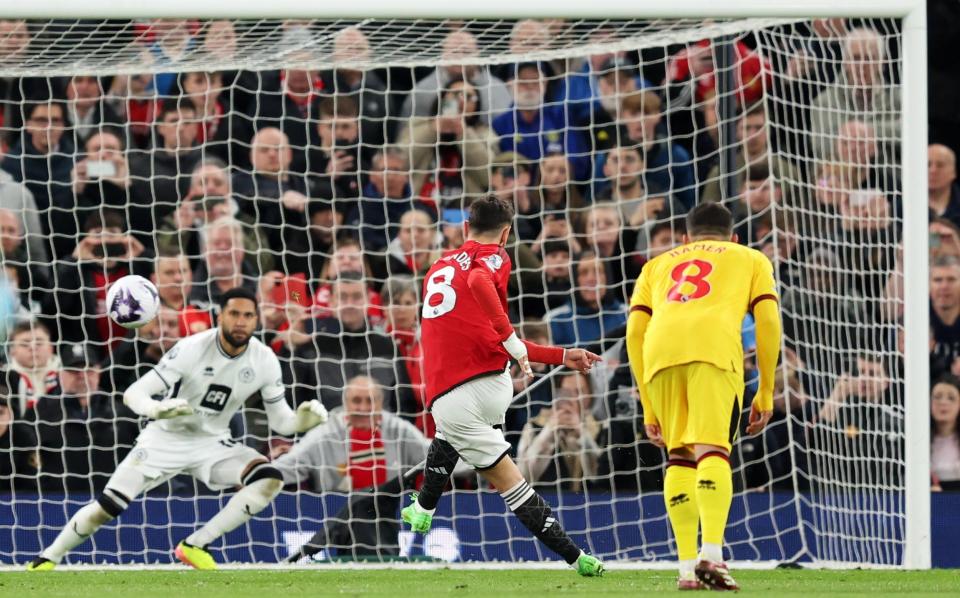 Bruno Fernandes of Manchester United scores his team's first goal from a penalty kick past Wes Foderingham of Sheffield United during the Premier League match between Manchester United and Sheffield United at Old Trafford on April 24, 2024 in Manchester, England.