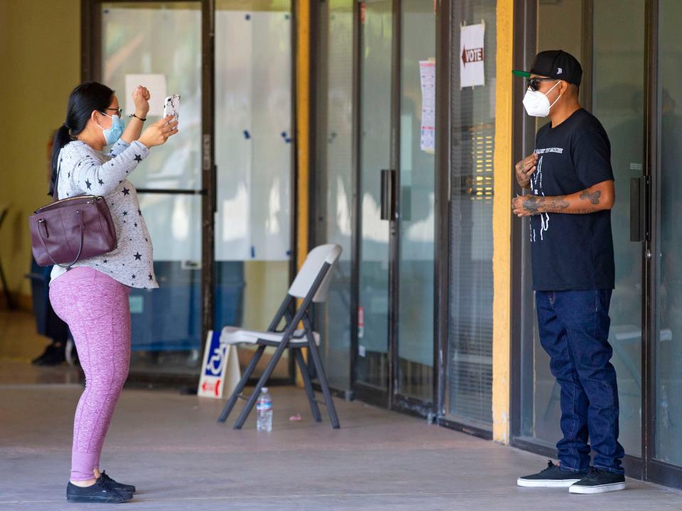 Alexandra Watson-Pattea cheers for her husband, T.J. Pattea, a first-time voter. The couple voted at Election Day at El Tianguis Mercado in Guadalupe, Ariz., on Nov. 3, 2020.