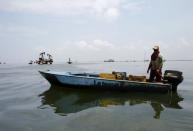 A raft is seen in Lake Maracaibo with oil pumps in the background, in Lagunillas, Ciudad Ojeda, in the in the state of Zulia, Venezuela, March 20, 2015. REUTERS/Isaac Urrutia