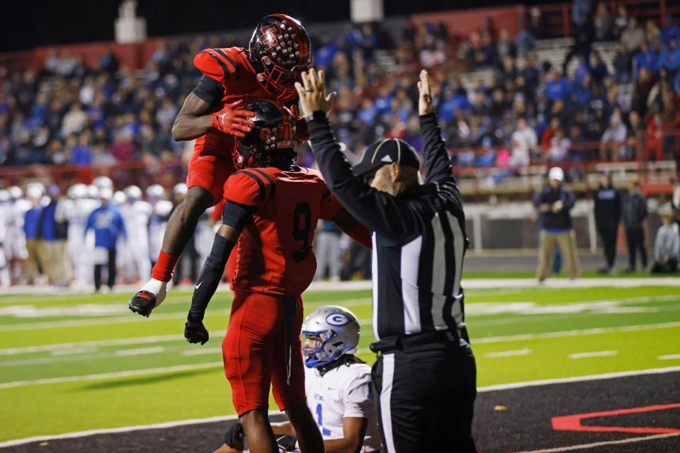 Del City's Braelon Adamah, left, celebrates with LaDainian Fields (9), middle, after Fields made a touchdown reception during a high school football game between Guthrie and Del City in the quarterfinals of the Class 5A playoffs in Del City, Okla., Friday, Nov. 17, 2023.