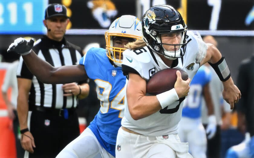 Inglewood, California September 25, 2022-Jaguars quarterback Trevor Lawrence breaks the tackle of Chargers linebacker Chris Rumph in the fourth quarter at SoFi Stadium Sunday. (Wally Skalij/Los Angeles Times)