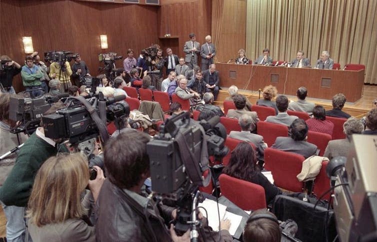 <span class="caption">Günter Schabowski (seated on stage, second from right) leads the press conference which led to the Fall of the Wall.</span> <span class="attribution"><a class="link " href="https://en.wikipedia.org/wiki/Fall_of_the_Berlin_Wall#/media/File:Bundesarchiv_Bild_183-1989-1109-030,_Berlin,_Schabowski_auf_Pressekonferenz.jpg" rel="nofollow noopener" target="_blank" data-ylk="slk:Bundesarchiv, Bild 183-1989-1109-030, Lehmann, Thomas;elm:context_link;itc:0;sec:content-canvas">Bundesarchiv, Bild 183-1989-1109-030, Lehmann, Thomas</a>, <a class="link " href="http://creativecommons.org/licenses/by-sa/4.0/" rel="nofollow noopener" target="_blank" data-ylk="slk:CC BY-SA;elm:context_link;itc:0;sec:content-canvas">CC BY-SA</a></span>