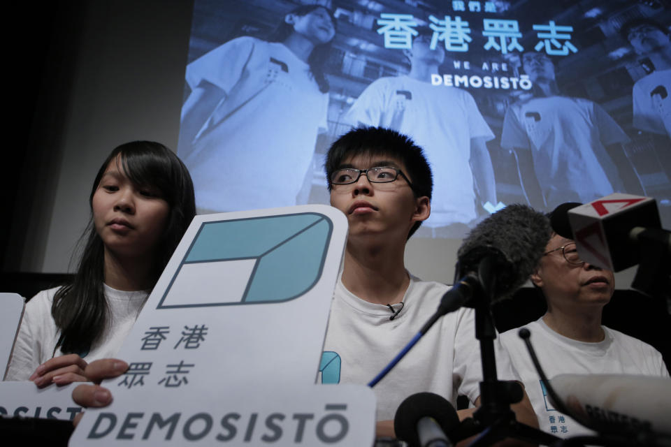 In this April 10, 2016, photo, Hong Kong teen activist Joshua Wong, center, and members of their new political party Demosisto listen to a reporter's questions as they officially unveiled during a press conference in Hong Kong. After a security law for Hong Kong passed in China, prominent Hong Kong pro-democracy activists Wong, Agnes Chow and Nathan Law issued statements on Facebook on Tuesday, June 30, 2020, saying they would withdraw from the pro-democracy organization Demosisto. Wong said "worrying about life and safety" has become a real issue and nobody will be able to predict the repercussions of the law, whether it is being extradited to China or facing long jail terms. (AP Photo/Vincent Yu)