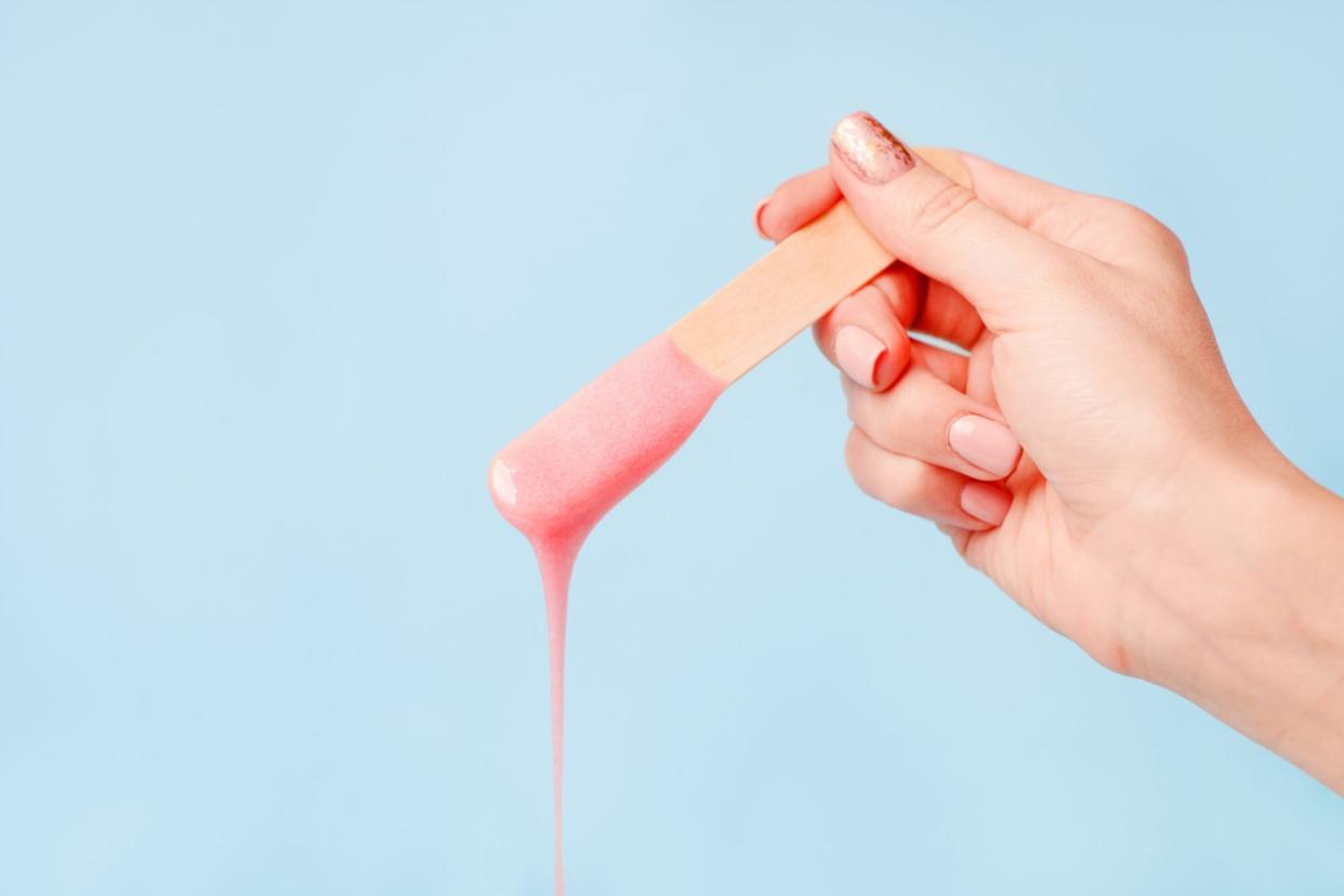 An image of a person holding a wax stick.