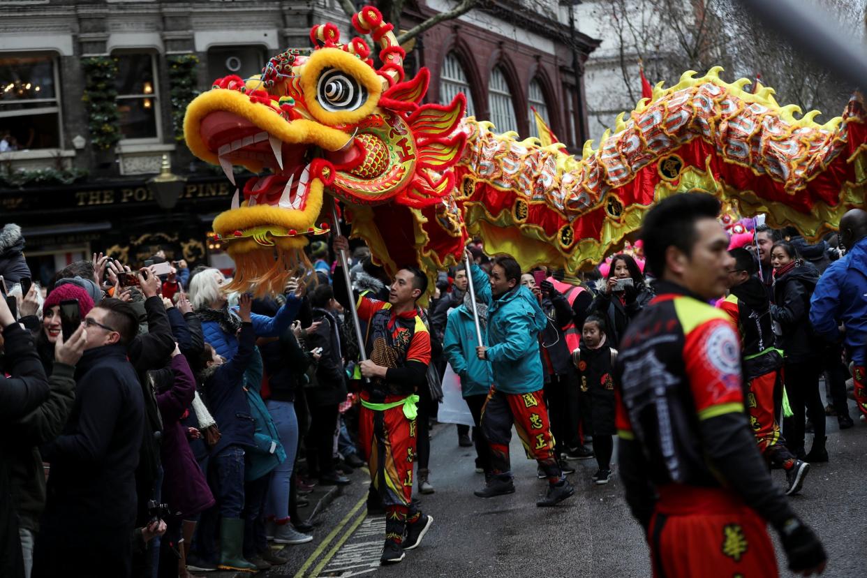 Spectators watch as performers move a traditional Chinese dragon through the crowd as they take part in the Chinese New Year parade through central London: REUTERS