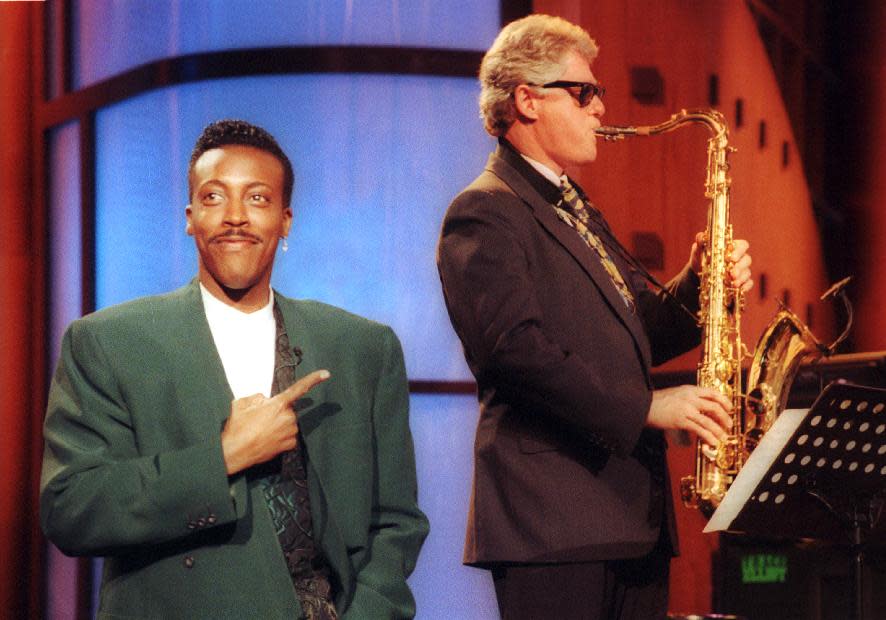 FILE - This June 3, 1992 file photo shows Arkansas Gov. Bill Clinton, right, playing the saxaphone with the band during the musical opening of "The Arsenio Hall Show, " in the Hollywood section of Los Angeles. The role of female talk-show hosts in late-night TV network history, all 50-plus years of it, can be summed up in two words: Joan Rivers. It takes just another two _ Arsenio Hall _ to do the same for minorities. There's no indication that's going to change in the latest round of musical chairs involving "Tonight" and "Late Night." (AP Photo/Reed Saxon, file)